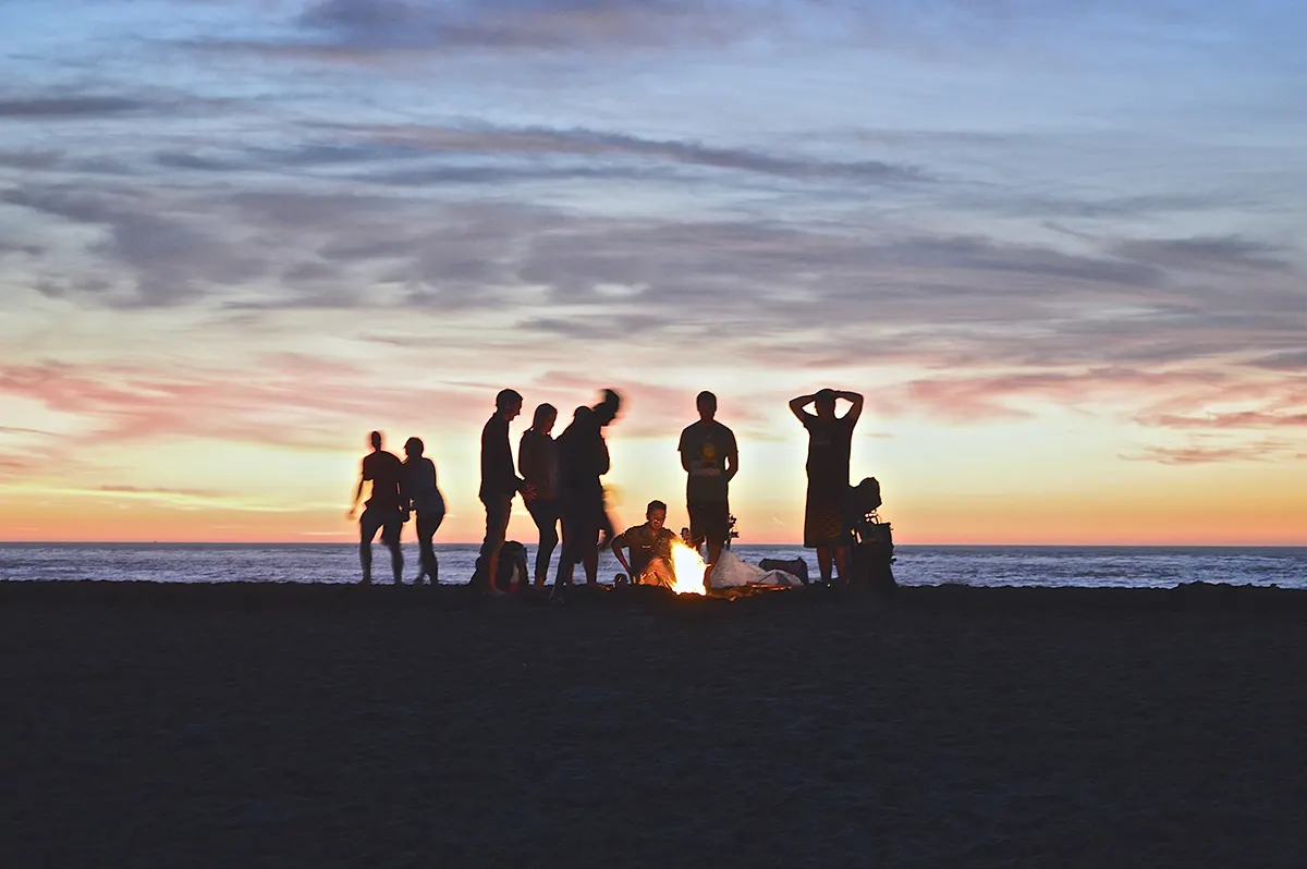 Groupe de jeunes sur la plage au coucher du soleil