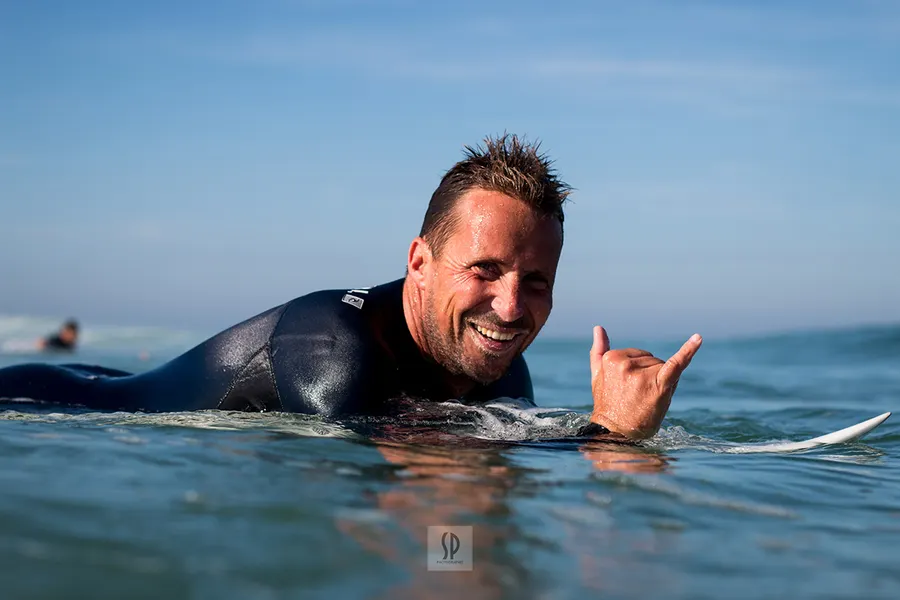 Un surfeur sourit dans l'eau